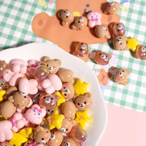 Close-up of pink bear and yellow star resin beads for DIY jewelry making kits