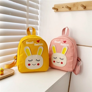 Detail of yellow and pink canvas toddler backpacks with cute cartoon rabbit faces