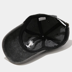 Detail of adjustable metal buckle and coconut tree embroidery on the cotton cap brim