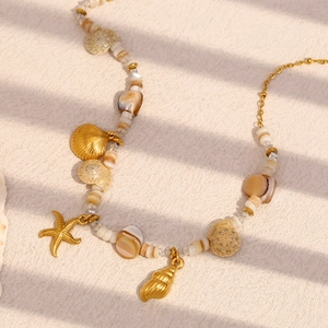 Detail view of 18K gold plated starfish shell charms on a stainless steel chain necklace