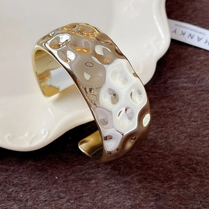 Minimalist wide open bangle with gold hammered texture and oval acrylic bone design