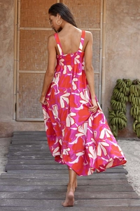 Close-up of vibrant floral print dress featuring a smocked back and sexy open-back design