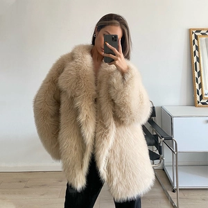 Detailed view of beige long faux fox fur coat featuring an oversized lapel and plush texture