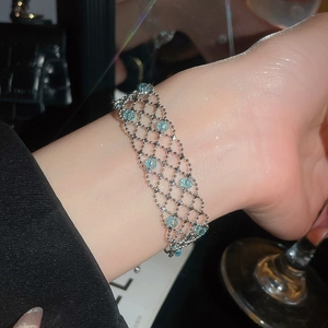 Close-up of elegant silver mesh bracelet with light blue crystal beads on a female wrist