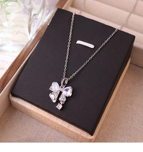 Vue macro du pendentif nœud en argent avec zircons sur une carte noire