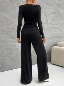 Rear view of black off-shoulder long-sleeve top and wide-leg trousers set for women