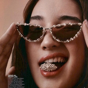 Close-up of luxury cat-eye sunglasses with rhinestone edges and dark brown lenses