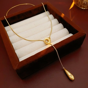 Detail of gold-plated Y-shaped necklace with water drop pendant and heart detail