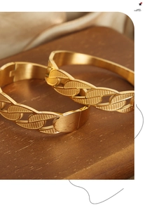 Macro view of gold-plated chain link bracelet with intricate mesh texture and secure clasp