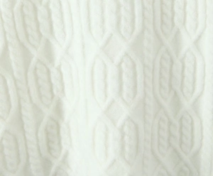 Macro detail of white cable knit fabric showing the textured pattern and woven structure