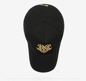 Top view of a black baseball cap featuring detailed gold embroidery on cotton fabric