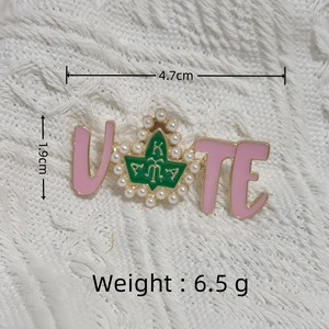 Pink enamel VOTE brooch with AKA Greek letters and pearl leaf accent on white fabric