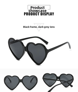 Detail view of heart-shaped sunglasses featuring black frames and sturdy metal hinges
