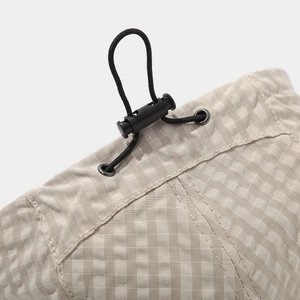 Detail of British check flat cap with adjustable elastic drawstring and plastic cord lock
