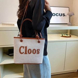 Stylish off-white canvas tote bag with brown leather trim and Cloos lettering