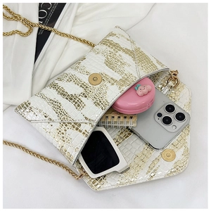 Interior view of crocodile pattern clutch showing space for phone, sunglasses and cosmetics