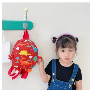 Detail of red toddler backpack with colorful dinosaur prints and adjustable straps