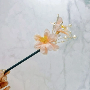Détail de fleurs en soie rose et perles sur un pic à cheveux chinois traditionnel