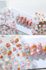 Close-up of 3D embossed nail stickers featuring cute rabbits and strawberry cake designs