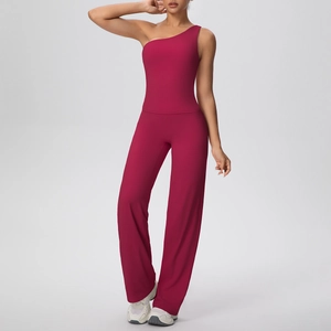 Détail d'un ensemble de yoga magenta avec haut asymétrique et pantalon large fluide