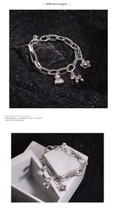 Detailed macro view of vintage silver charm bracelet with floral and lucky pouch pendants