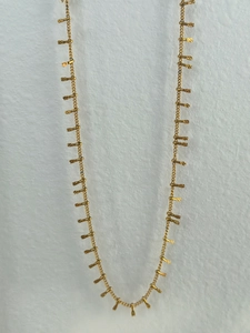 Detail of vintage 18k gold plated waist chain featuring textured cylindrical pendants