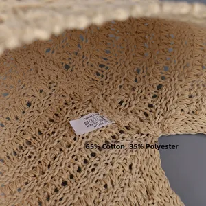 Detail of hand-woven cotton straw bucket hat showing breathable texture and 65% cotton label