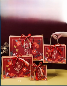 Set of four red Chinese wedding gift bags in various sizes with gold calligraphy and bows
