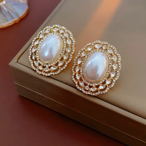 Detailed macro view of vintage gold earrings with imitation pearl and marquise rhinestones