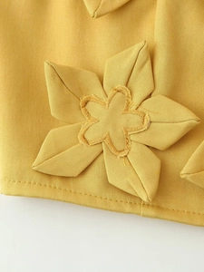 Gros plan sur le tissu jaune avec décoration florale 3D et broderie sur la jupe