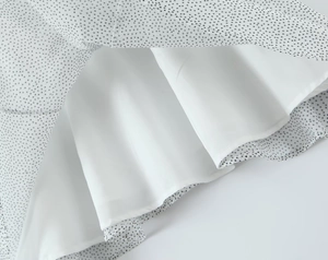 Detail view of the white chiffon fabric with black polka dots and a soft white lining