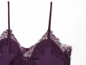 Dettaglio del camisole in pizzo viola scuro con trama a rete e spalline sottili