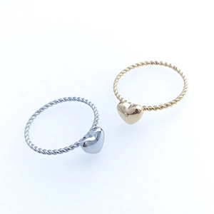 Macro view of gold and silver twisted heart rings with a polished metal finish