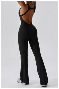 Close-up of cross-strap back detail and flared leg of black yoga jumpsuit