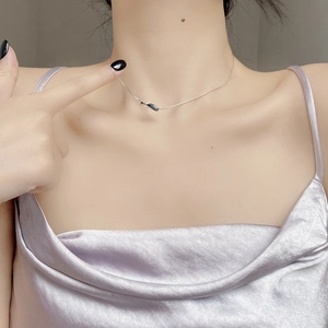 Close-up of a minimalist silver twisted bar pendant on a sleek snake chain for women