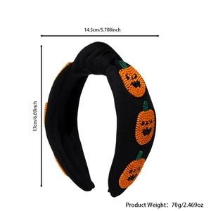 Detail of wide black Halloween headband featuring three orange beaded pumpkin patterns