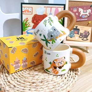 Ceramic mugs with cartoon koala and panda prints and matching yellow gift packaging