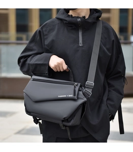 Detail of a black tactical crossbody bag with multi-layer design and adjustable strap
