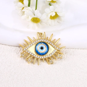Detail of 18K gold plated sun-shaped evil eye pendant with blue crystal and small zircons