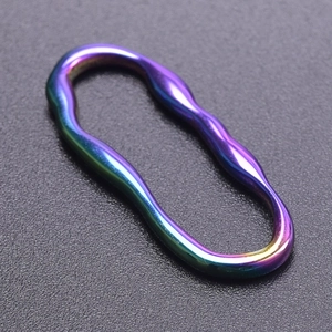 Makro-Detail von ovalem Edelstahlring mit gedrehter Wellenstruktur und Regenbogen-Finish