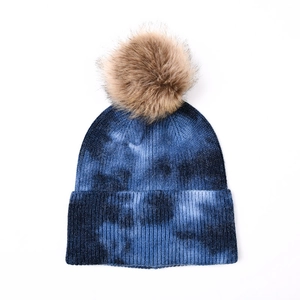 Bonnet en maille tie-dye bleu foncé et noir avec pompon moelleux en fausse fourrure