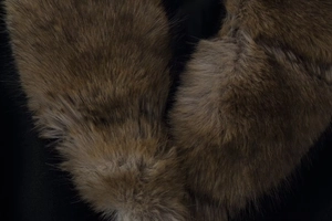 Macro shot of dark brown faux fur texture showing soft plush details of the large collar