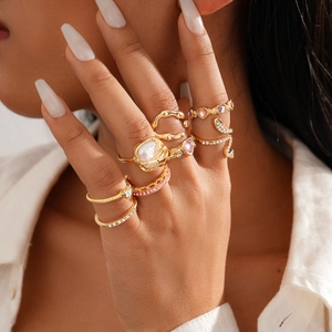8-piece gold geometric heart ring set with pink zircon and pearls on woman's hand