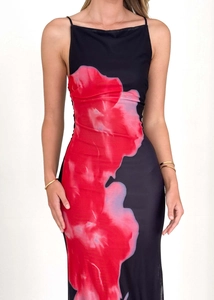 Détail de l'imprimé floral rouge sur la robe noire à fines bretelles et tissu lisse