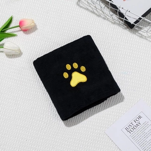 Detail of soft black coral fleece pet towel featuring a yellow cat paw embroidery