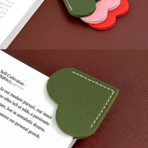 Detail of heart-shaped PU leather bookmark with white stitching and leather texture