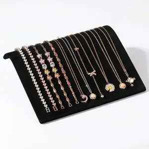 S-shaped jewelry display board with various gold and silver necklaces and bracelets