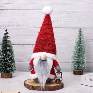 Christmas faceless gnome figurine with red knit hat and oil lamp on wooden base