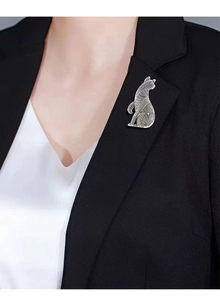 Close-up of a vintage silver cat brooch with hollow texture on a black blazer lapel