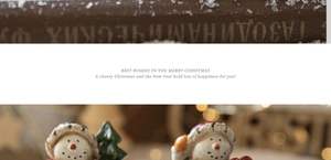 Close-up of a resin snowman figurine with holiday greetings on a warm festive background
